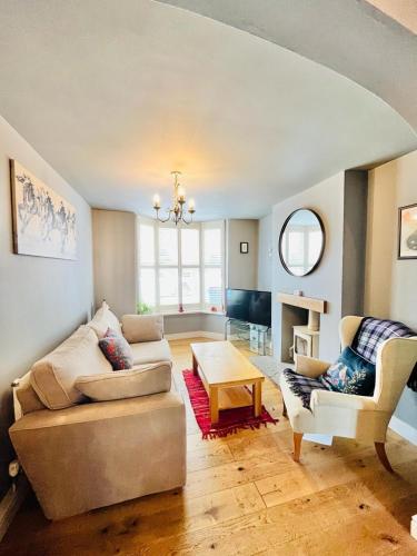 a living room with a couch and a table at Luna Cottage - Grove Road Cottages in Stratford-upon-Avon