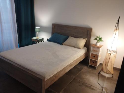 1 dormitorio con 1 cama grande y cabecero de madera en T3 Cosy Côté Lagon, en Saint-Leu