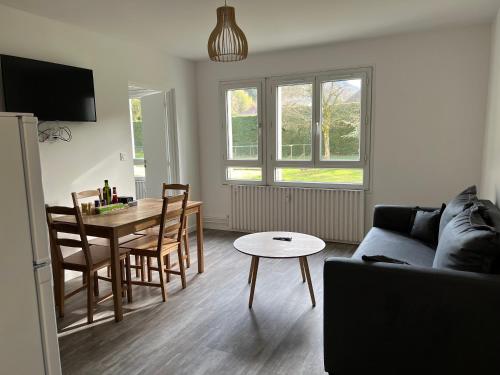 a living room with a couch and a dining room table at Les jardins du Moiron in Le Champ-près-Froges