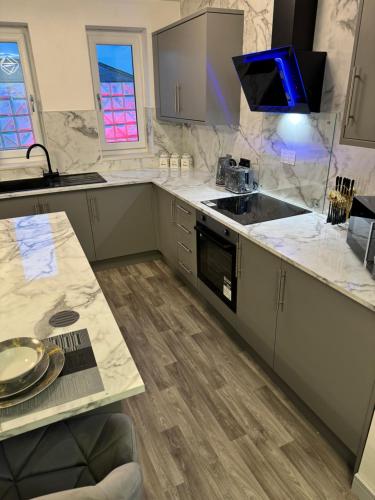 a kitchen with marble counter tops and a sink at 2 Bedroom Luxury Apartment Prince Street Bridlington Sleeps 5 in Bridlington