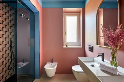 a bathroom with a toilet and a sink and a mirror at Santarosa Rooms in Florence
