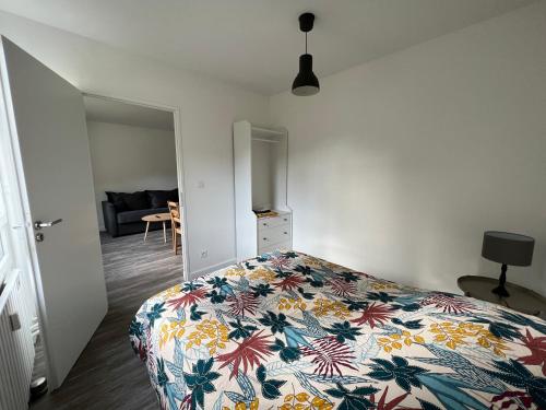 ein Schlafzimmer mit einem Bett mit einer farbenfrohen Tagesdecke in der Unterkunft Les jardins du Moiron in Le Champ-près-Froges