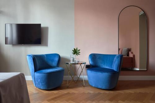 two blue chairs in a room with a mirror at Santarosa Rooms in Florence