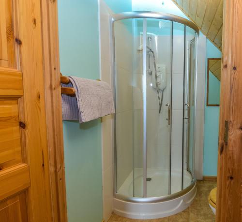 a shower with a glass door in a bathroom at The New Farmhouse in Biggar