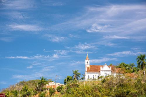 une église au sommet d'une colline avec un ciel bleu dans l'établissement Pousada Suiça, à Santa Leopoldina