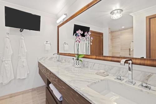 a bathroom with a sink and a large mirror at Timbers Kauai Ocean Club & Residences in Lihue