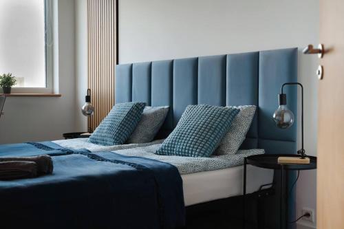 a bedroom with a bed with a blue headboard at Sapphire Room Hotel Lechicka in Poznań