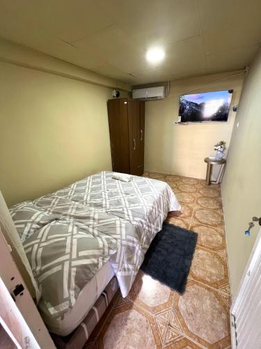 a bedroom with a bed and a tv on the wall at CÓMODA HABITACIÓN CENTRAL in Machala
