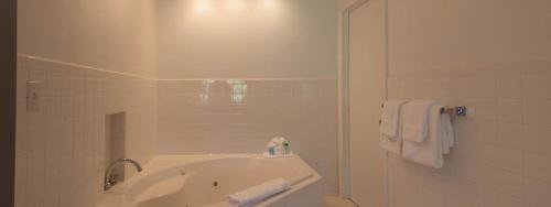 a white bathroom with a tub and a shower at The Atlantic in Southampton