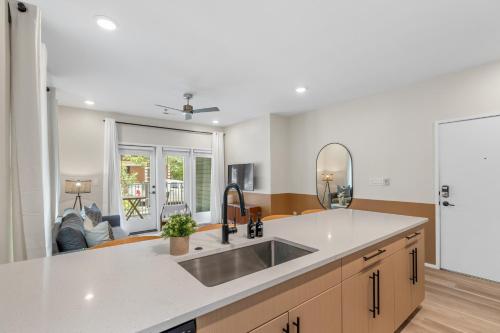 a kitchen with a sink and a living room at Winton Flats by MilaPad in Atlanta