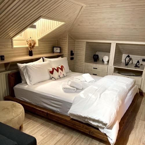 een slaapkamer met een groot bed met witte lakens bij Memories Apartments Μονοκατοικία στο Καρπενήσι in Karpenisi