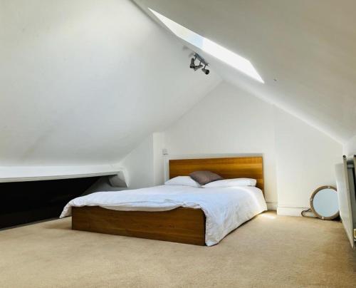 a bedroom with a bed in a white room at Bodhi Tree Cottage - Grove Road Cottages in Stratford-upon-Avon