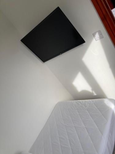 a bedroom with a bed and a television on the wall at 2BR-Sleeps3-Parking-NearBeach in Mablethorpe