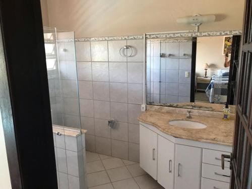 W łazience znajduje się umywalka oraz prysznic z lustrem. w obiekcie Pousada Encantos do Roncador w mieście Barra do Garças