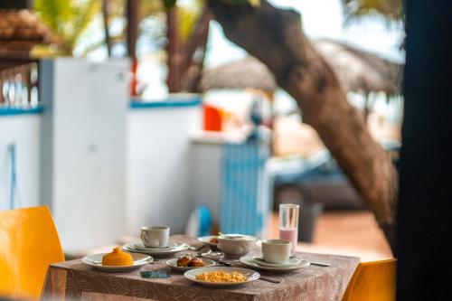 a table with plates of food on top at Apprezzare . Pousada beira-mar in Porto De Galinhas