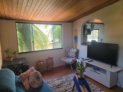 uma sala de estar com uma grande televisão de ecrã plano em Studio 1 casazul em Salvador