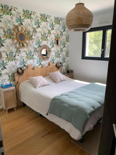 a bedroom with a bed with a floral wallpaper at Villa Jasmin in Gradignan