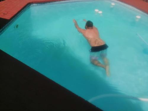 mężczyzna pływający w basenie w obiekcie Pretoria East Guests w mieście Pretoria