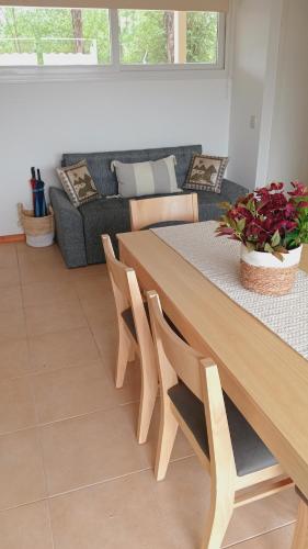 ein Wohnzimmer mit Tisch und Couch in der Unterkunft Condominio Monte Molinos - dpto en Nautico, 2 dormitorios y vista al lago in Villa Ciudad de America