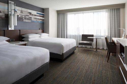 a hotel room with two beds and a desk at Kansas City Marriott Country Club Plaza in Kansas City