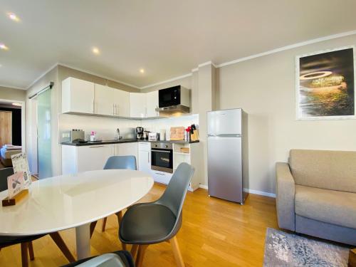 a living room with a white table and a kitchen at Amaroo - Apartments "Branden" in Potsdam