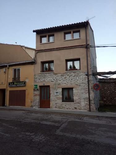 an old stone building on the side of a street at Casa Valle del Lozoya in Rascafría