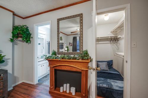 uma sala de estar com lareira e espelho em Cozy Texas Vacation Rental Near Lewisville Lake! em Lake Dallas