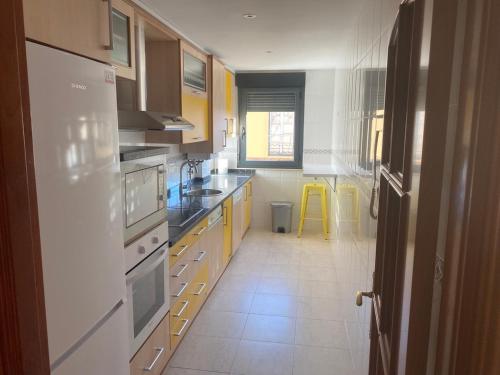 una cocina con armarios amarillos y electrodomésticos blancos en LAS ALBRICIAS en León