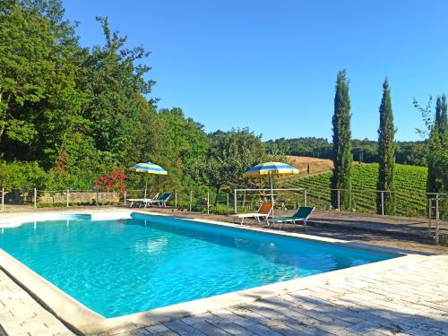 een zwembad met 2 stoelen en 2 parasols bij Agriturismo San Bernardino Del Lago in Rapolano Terme