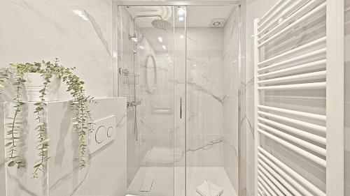 ein weißes Bad mit einer Dusche und einer Glastür in der Unterkunft Viva Riviera Brand New Top Floor close Croisette in Cannes