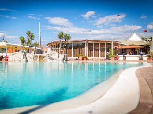 una piscina con acqua blu di fronte a un edificio di Residence Arco delle Rose ad Agropoli