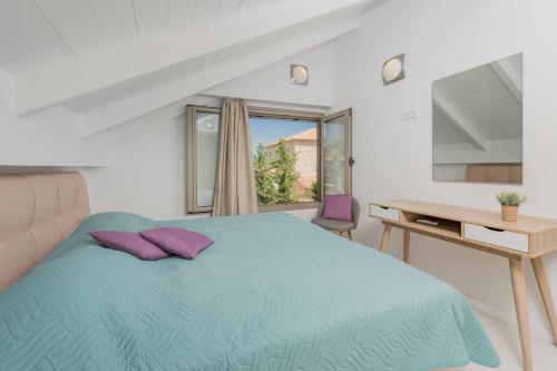 a bedroom with a blue bed and a desk and a window at Villa Lefki Sofita in Makris Gialos