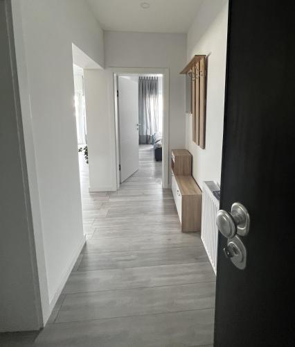 a hallway with white walls and wooden floors and a door at Noemie Apartmani in Zagreb