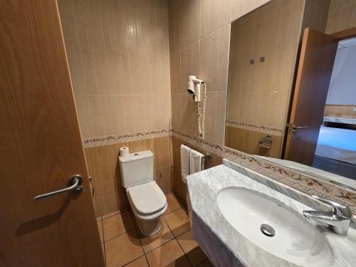 a bathroom with a sink and a toilet and a mirror at Rambla Alicante Contactless in Alicante