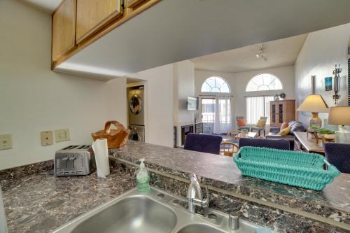 eine Küche mit einem Waschbecken und ein Wohnzimmer in der Unterkunft Long Beach Condo with Pool Access, 1 Mi to Downtown! in Long Beach