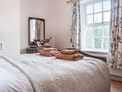 1 dormitorio con 1 cama con 3 almohadas en Vintage Cottage, en Luddenden Foot