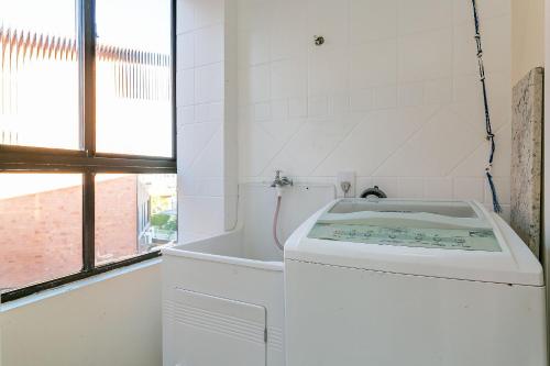 uma casa de banho branca com uma banheira e um lavatório em Apto aconchegante a 110m do mar em Floripa EVE203 em Florianópolis