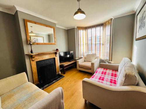 a living room with a couch and a fireplace at Edwards Cottage - Grove Road Cottages in Stratford-upon-Avon