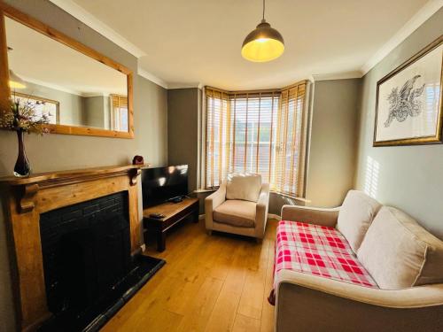 a living room with a couch and a fireplace at Edwards Cottage - Grove Road Cottages in Stratford-upon-Avon