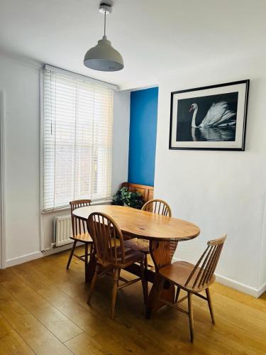 a dining room with a wooden table and chairs at Edwards Cottage - Grove Road Cottages in Stratford-upon-Avon