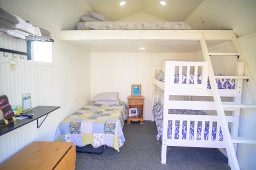 a bedroom with a bunk bed and a ladder at Genas's Sierra Inn & Restaurant in Dunlap