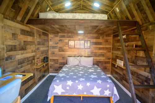 a bedroom with a bed in a wooden cabin at Genas's Sierra Inn & Restaurant in Dunlap