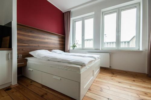 1 dormitorio con cama blanca y pared roja en Smolna Apartments by Your Freedom, en Varsovia