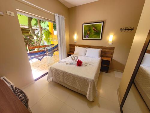 a hotel room with a bed and a balcony at Pousada Som dos Pássaros in Porto De Galinhas