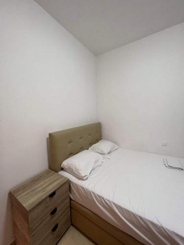 a small bedroom with a bed and a nightstand at Hotel Orion Apartment in Katerini