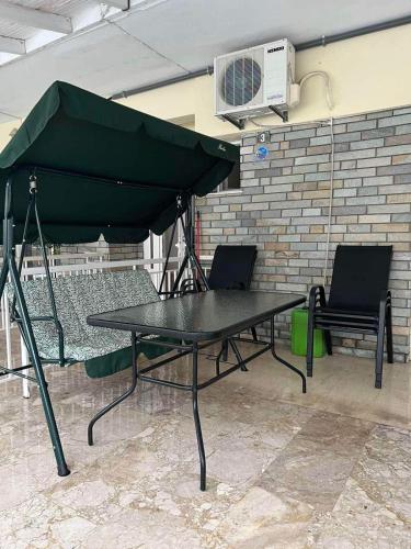 a picnic table with two chairs and an umbrella at Hotel Orion Apartment in Katerini