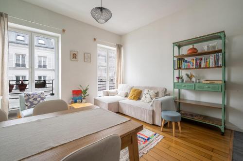 un salon avec un canapé et une table dans l'établissement Appartement L'Epique - Welkeys, à Paris