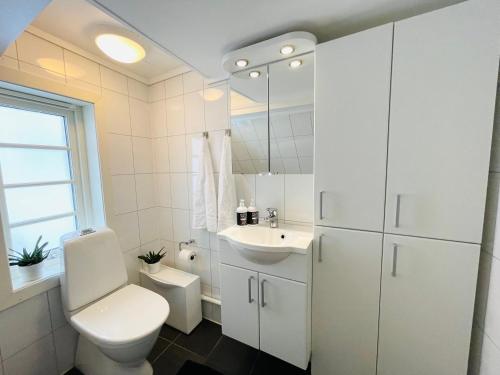 a white bathroom with a toilet and a sink at Central Economic Stavanger Kongsteinsgata in Stavanger