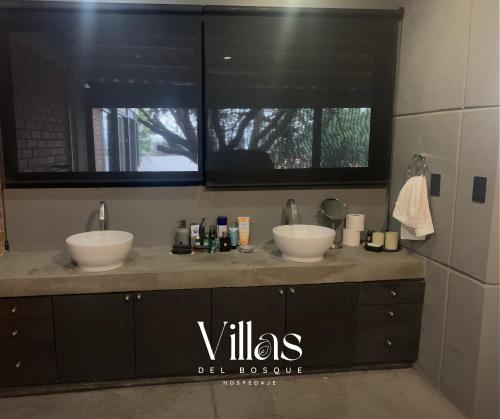 a bathroom with two sinks and two windows at Villas del Bosque in El Pueblito