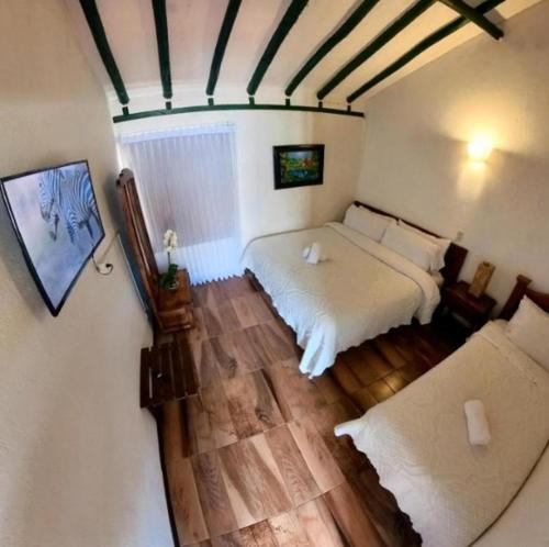 a bedroom with a white bed and a wooden floor at hotel abahunza in Villa de Leyva